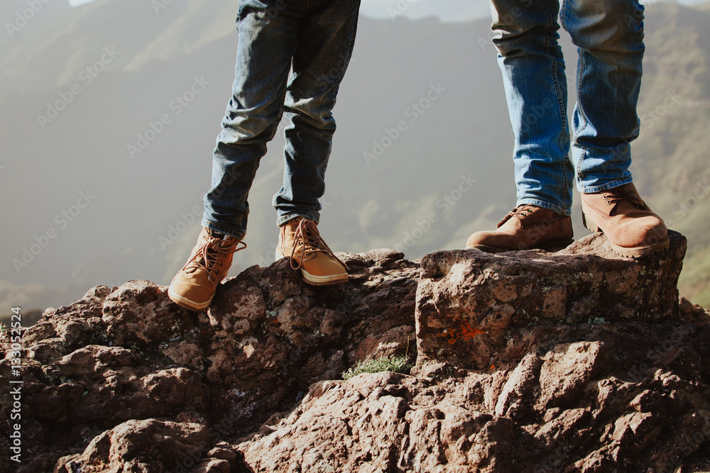 father and son hiking boots in mountains father and son hiking boots in mountains