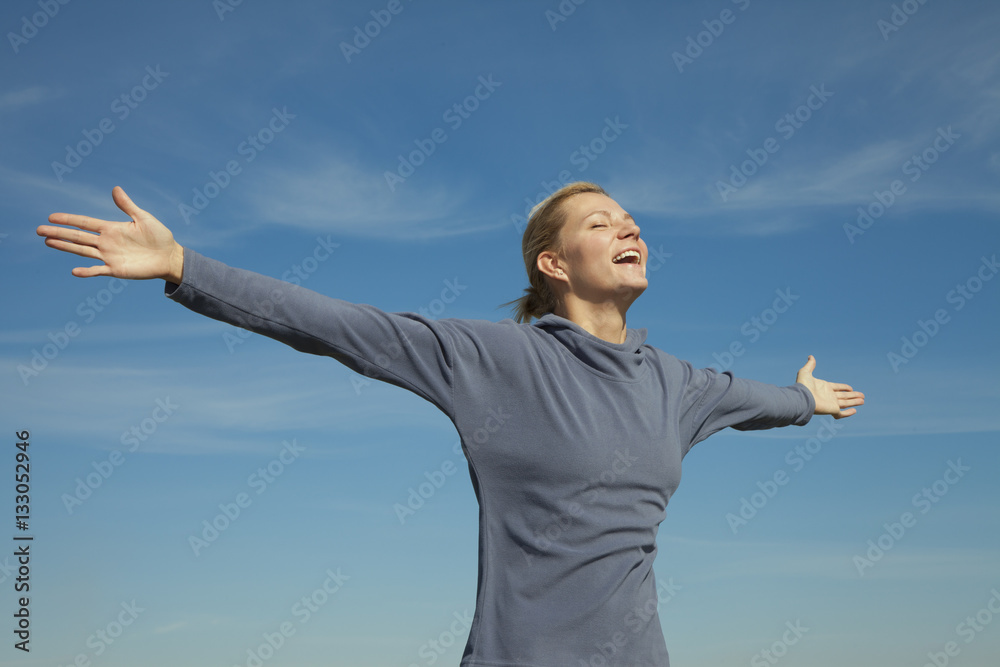 Side view of a young woman stretching her against the sky bg Side view of a young woman stretching her against the sky bg