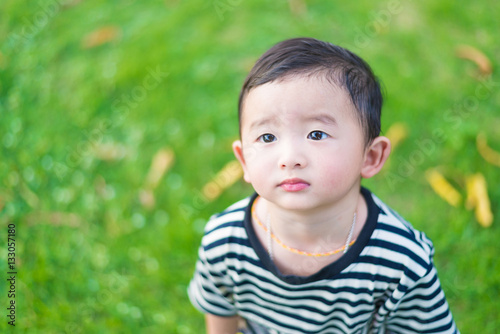 Close-up little Asian boy looking up somewhere and thinking with