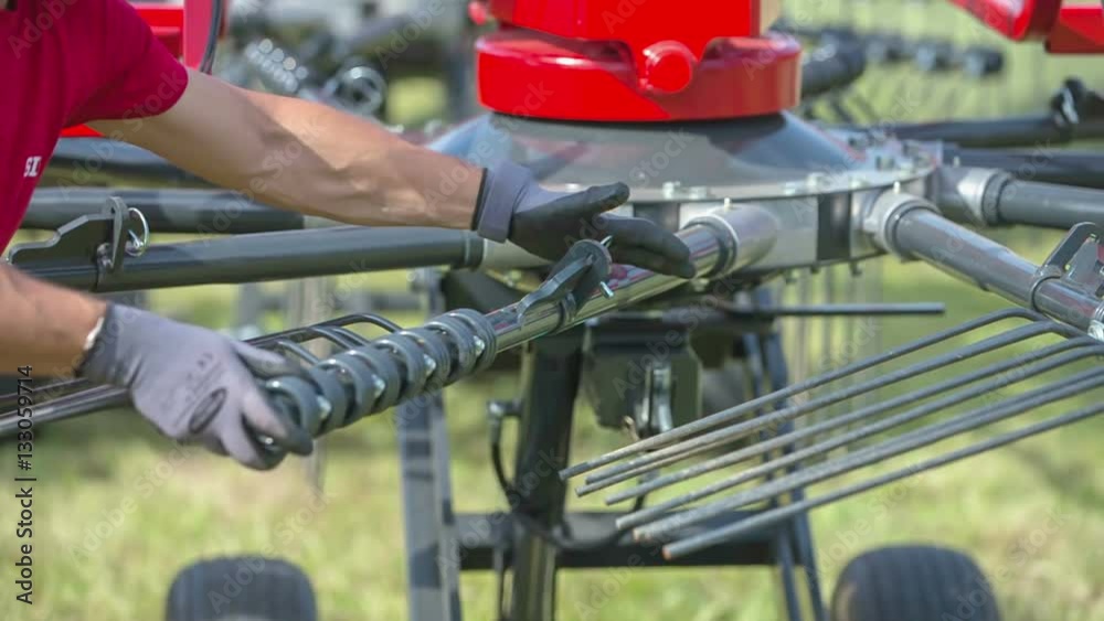 A farmer has fixed the rotary rake and now, he is putting it back on a machinery. It will work properly.
A farmer has fixed the rotary rake and now, he is putting it back on a machinery. It will work properly.