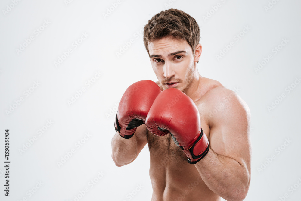 Attractive young man boxer standing over white background