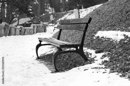 Black and white photo of abandoned bench in the park. Winter in Cluj-Napoca photo