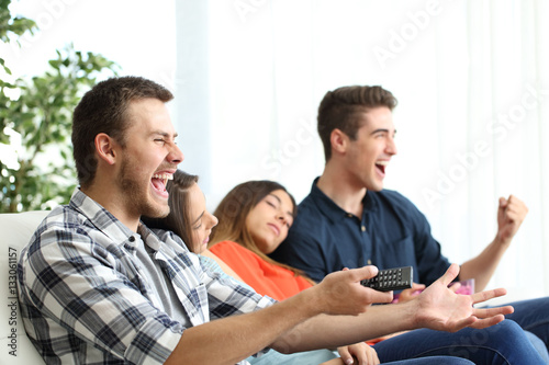Excited men watching tv and bored girlfriends
