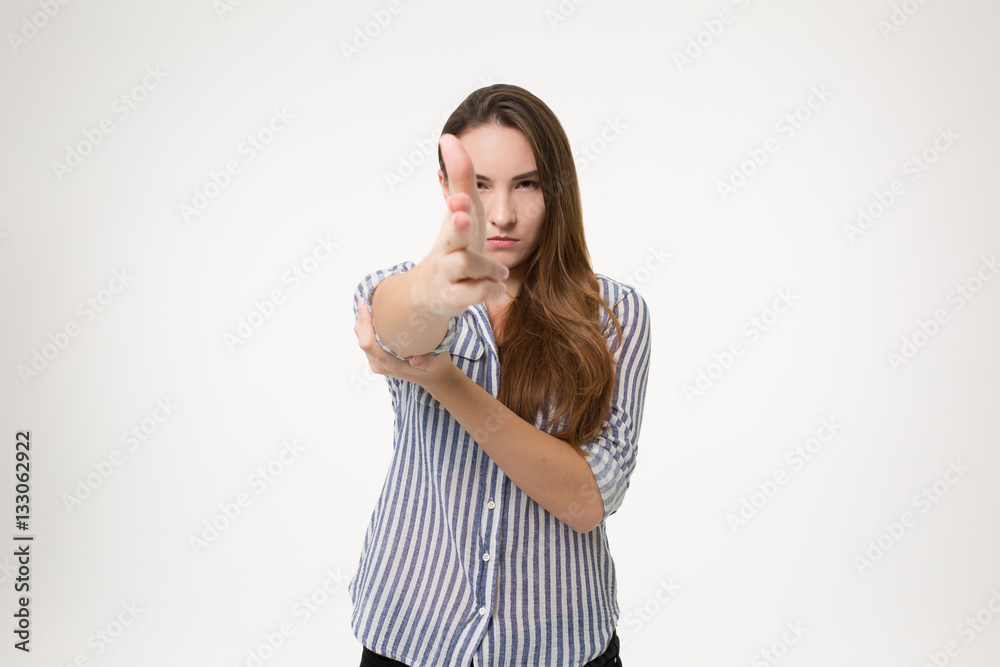 girl pointining finger gun at you and looking dangerous over white background isolated girl pointining finger gun at you and looking dangerous over white background isolated