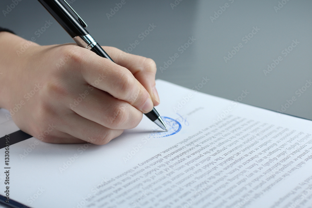 Male businessman's hand signs papers.. Male businessman's hand signs papers..