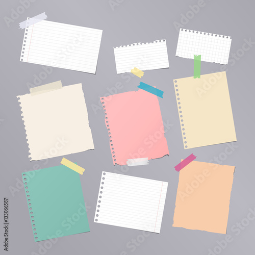 Pieces of different size colorful note, notebook, copybook paper sheets stuck with sticky tape on gray background