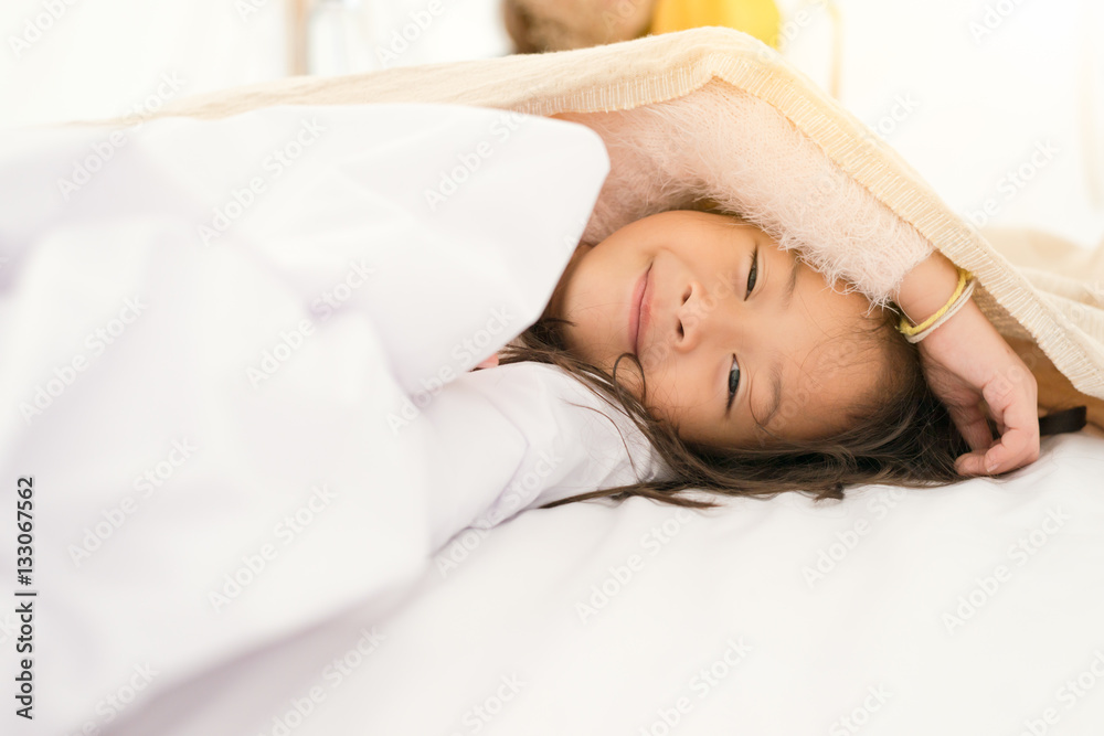 Little girl laying on bed and looking to camera Little girl laying on bed and looking to camera