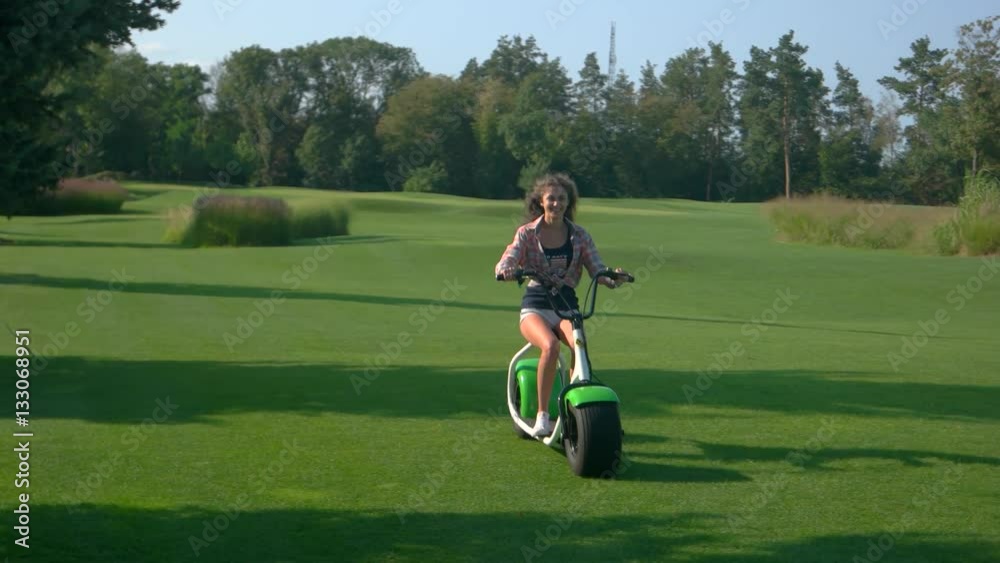 Smiling lady on electric scooter. Young woman outdoors. Transport of new generation. Smiling lady on electric scooter. Young woman outdoors. Transport of new generation.