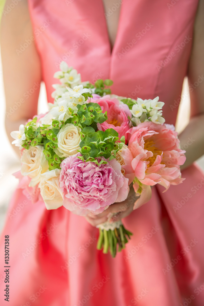 Beautiful wedding bouquet, peonies, in hands of the bride