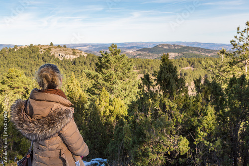 Bilde på lerret Kvinna tittar ut över bergslandskap från ett snötäckt berg