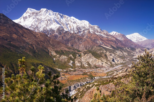 Nepalese village on Manang in the valley of Marsyangdi river, Humde airport, Annapurna III mountain summit on background, Annapurna Circuit Trek, Himalaya, Nepal, Asia. horizontal view photo