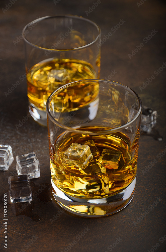 Glass of whiskey with ice on the old rusty background Glass of whiskey with ice on the old rusty background