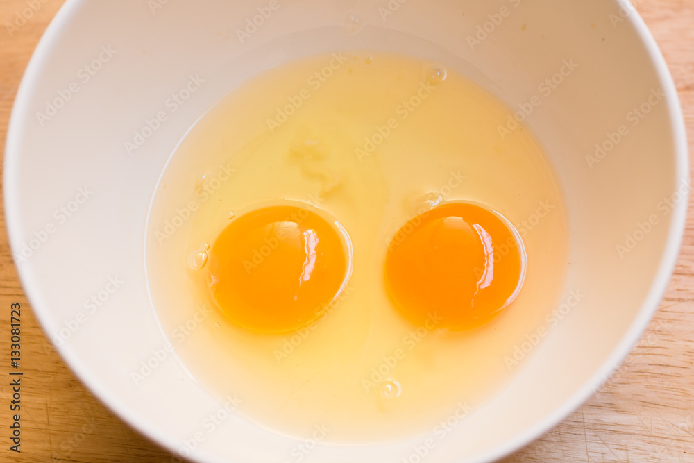 Raw egg in a bowl on wood borad Raw egg in a bowl on wood borad