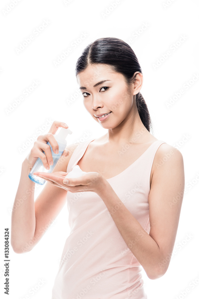 Young Asian woman pouring on hand cosmetic foam Young Asian woman pouring on hand cosmetic foam