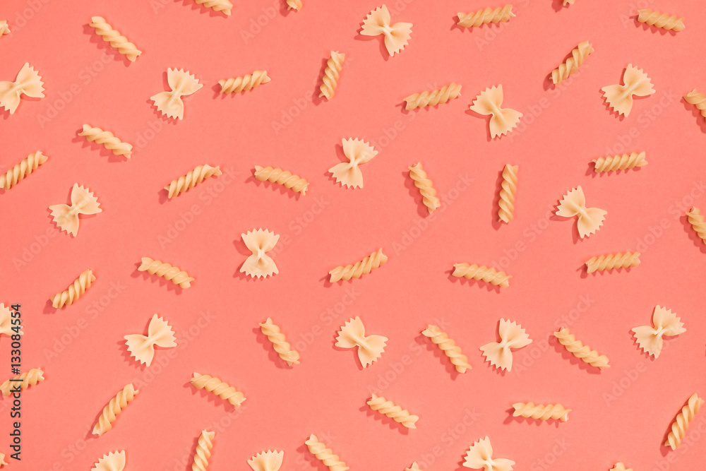 Fototapeta premium Farfalle and fusilli pasta flat lay pattern