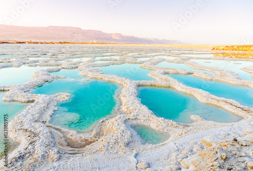 View of Dead Sea coastline. Salt crystals at sunset. Texture of Dead sea. Salty sea shore photo