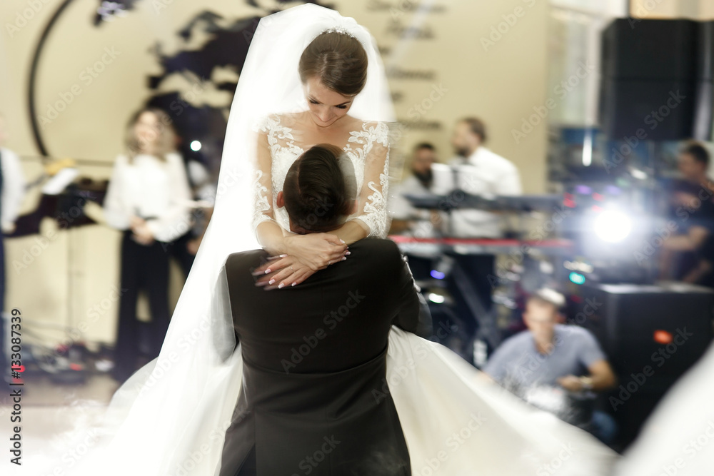 Blurred picture of groom holding bride up during their first dan