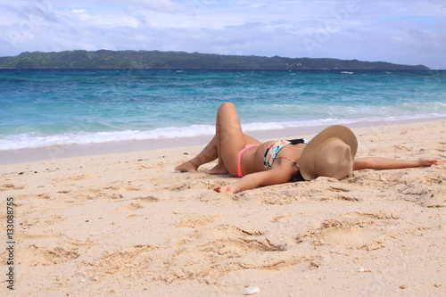 浜辺で寝そべる女性