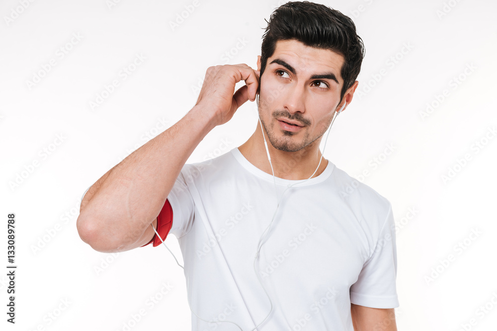 Portrait of a young sports man with earphones looking away Portrait of a young sports man with earphones looking away