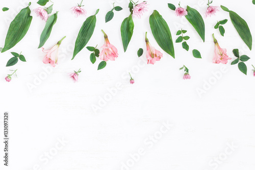Flowers composition. Border made of pink flowers and leaves. Top view  flat lay