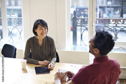 Asian businesswoman interviewing mixed race man in an office
