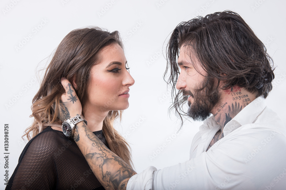 Beautiful couple looking and touching each other on white backgr Beautiful couple looking and touching each other on white backgr