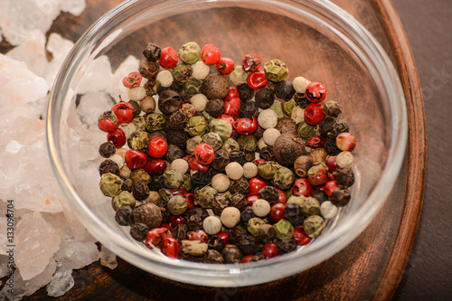 Set of whole peppercorns and rose salt. Handful of red, black, white peppercorns and salt on a argil plate. Herbs and spices concept