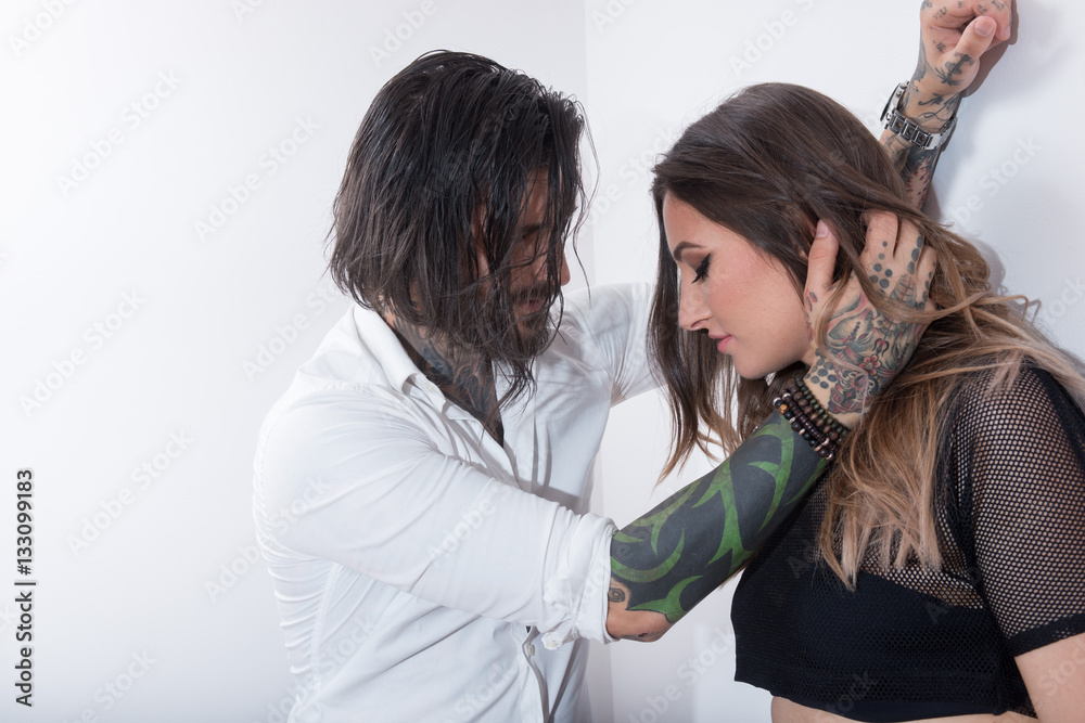 Sexy tattooed man touching a young woman
