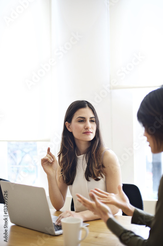 Young caucasian businesswoman in office with female colleague
