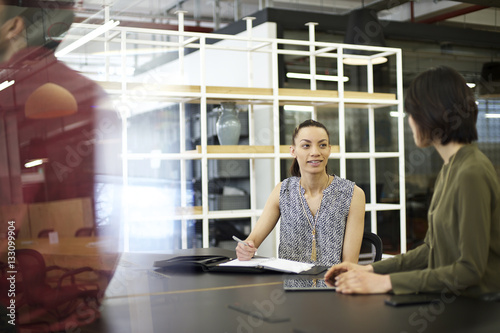 Young mixed race businesswoman in an office with colleagues