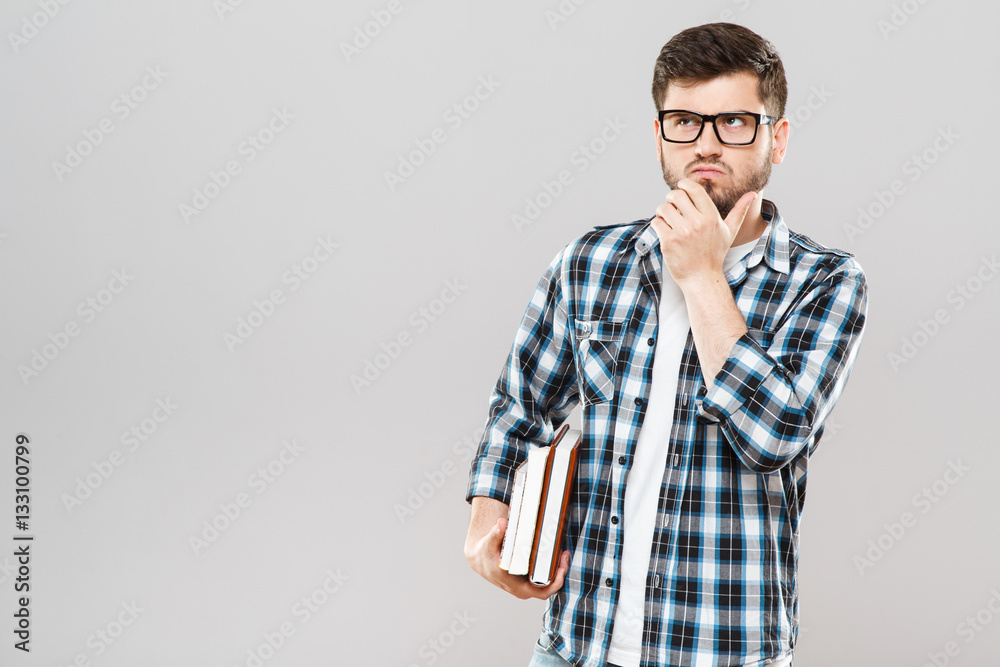 Thoughtful man holding colorful books Thoughtful man holding colorful books
