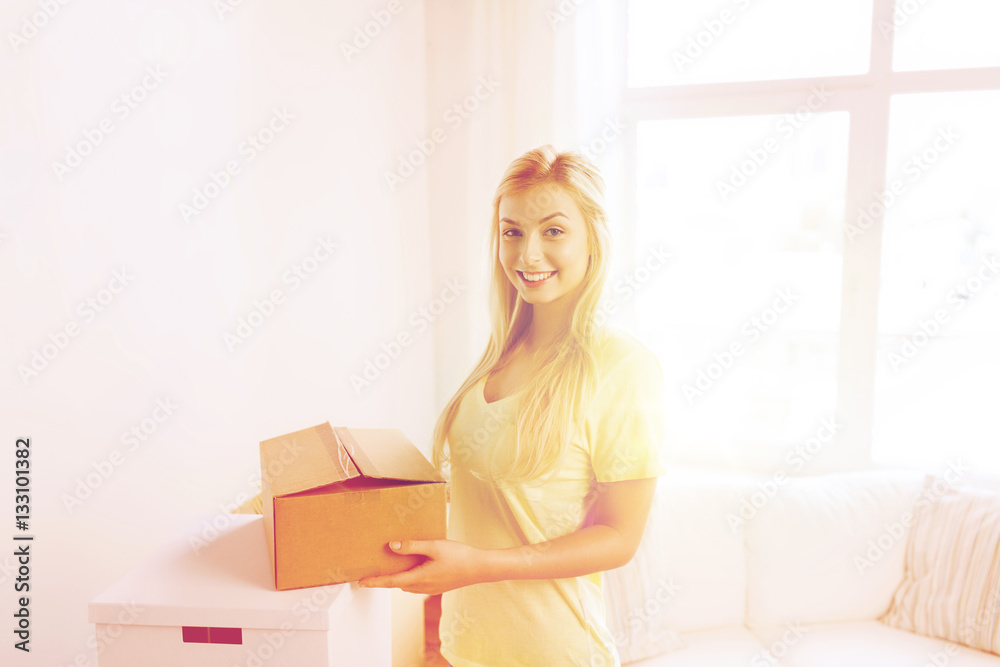 smiling young woman with cardboard box at home smiling young woman with cardboard box at home