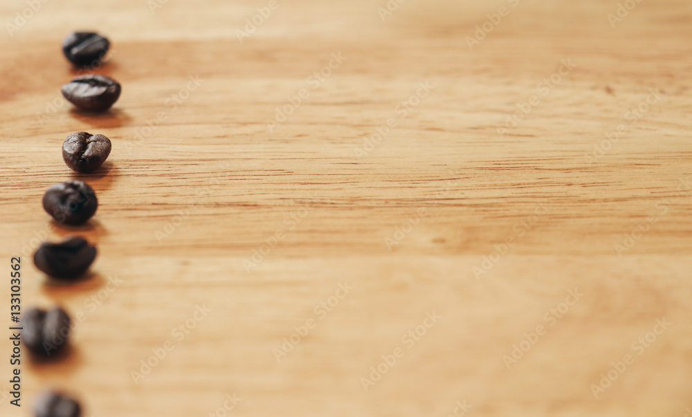 Obraz premium Kawowe fasole na drewnianym stole. Ton vintage. Selektywna ostrość. minimalna koncepcja.