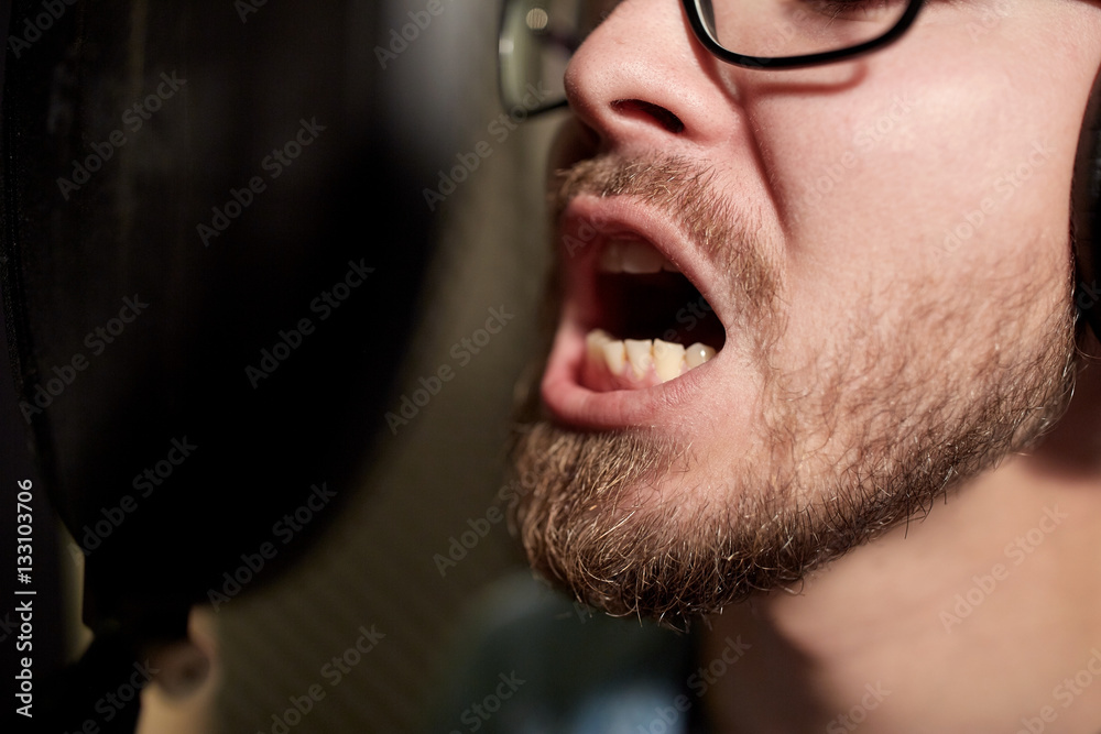 man with headphones singing at recording studio man with headphones singing at recording studio