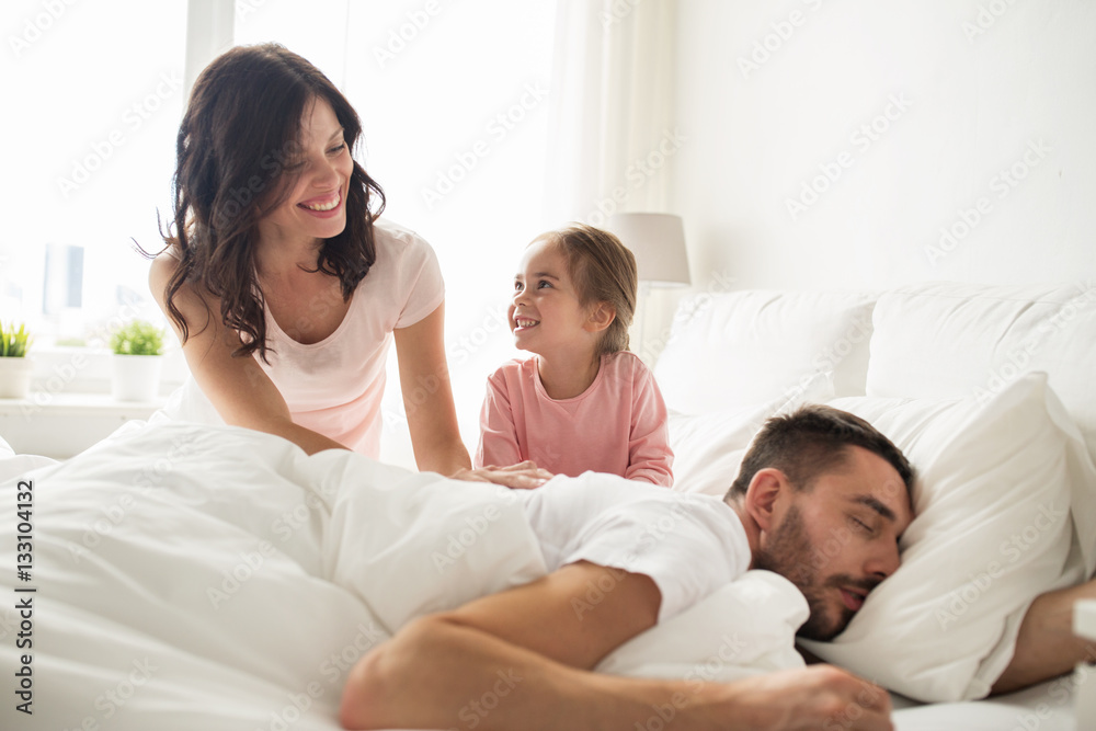 happy family waking up in bed at home happy family waking up in bed at home