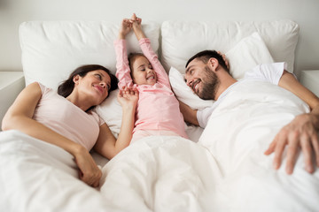happy family waking up in bed at home