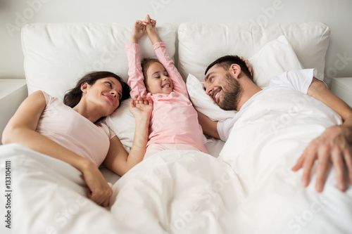 happy family waking up in bed at home photo