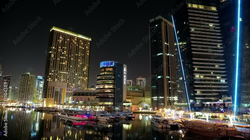 Dubai Marina night time lapse, United Arab Emirates. Dubai Marina - the largest man-made marina in the world. Dubai Marina is a canal city, carved along a 3 km stretch of Persian Gulf shoreline, UAE Dubai Marina night time lapse, United Arab Emirates. Dubai Marina - the largest man-made marina in the world. Dubai Marina is a canal city, carved along a 3 km stretch of Persian Gulf shoreline, UAE