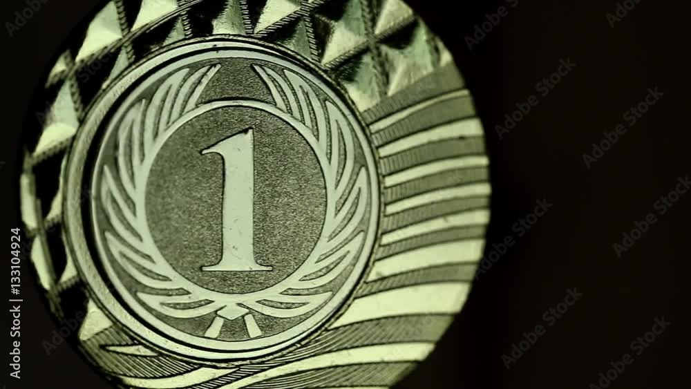 Medal for competition winner on black background. 1st place champion medallist. First place gold medal. Gold medal, awarded to the winner