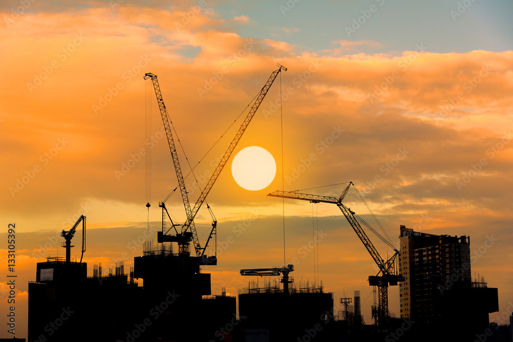 Construction site silhouette on tower building rooftop twilight