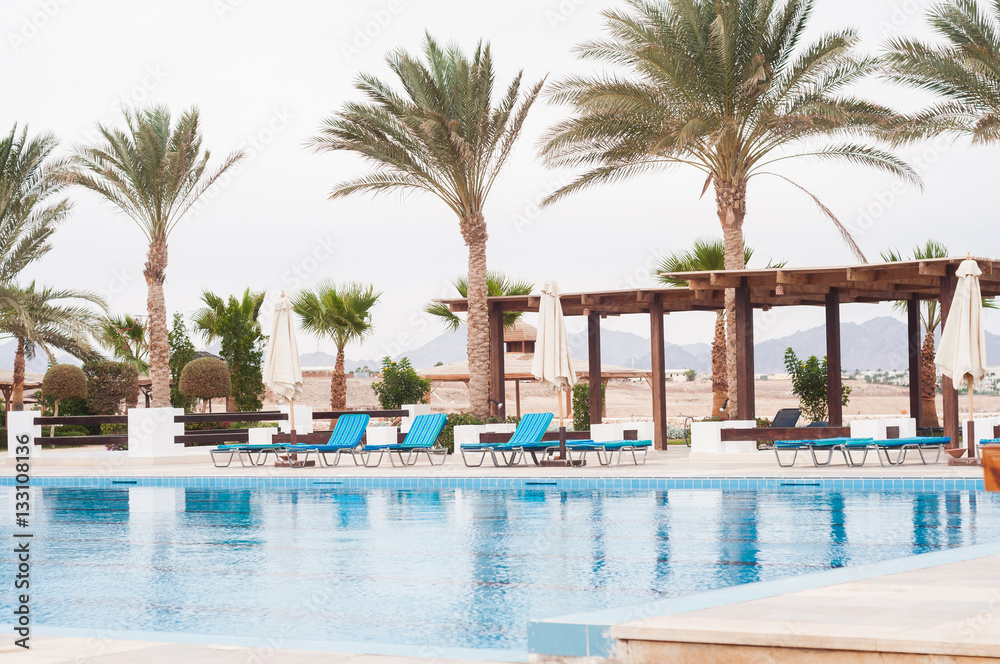 Swimming pool with stair in hotel. Summer photo concept.