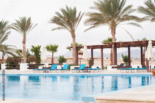 Swimming pool with stair in hotel. Summer photo concept.