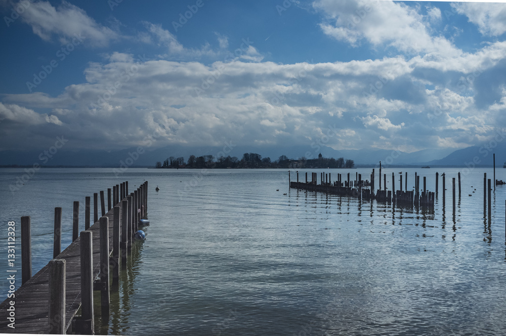 Jetty at the lake Chiemsee with blue sky and clouds, Chiemgau, Bavaria