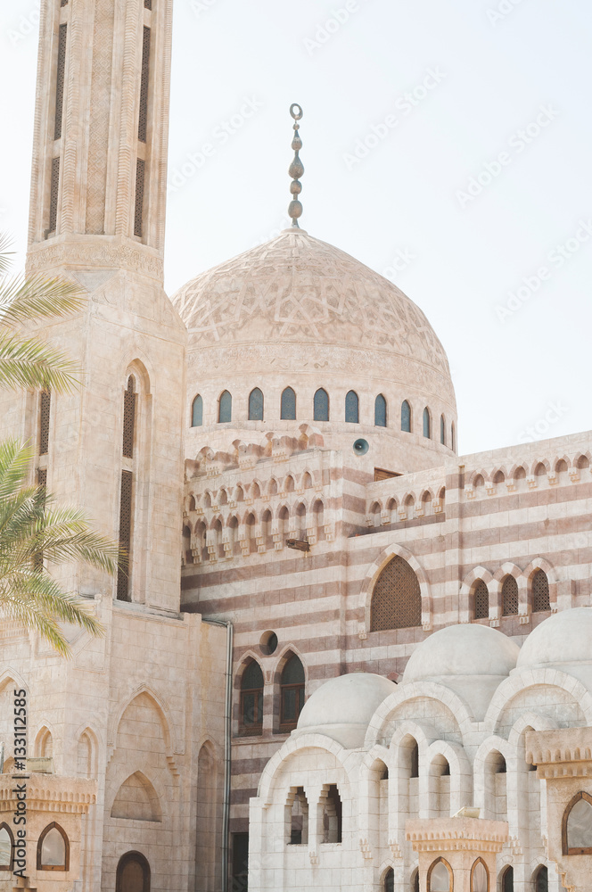 Obraz premium View of the tower of the ancient mosque. Mosque entrance ornament. Islamic ornaments on wall. Arab symbols. Al Mustafa Mosque Sharm El Sheikh. Ancient wall