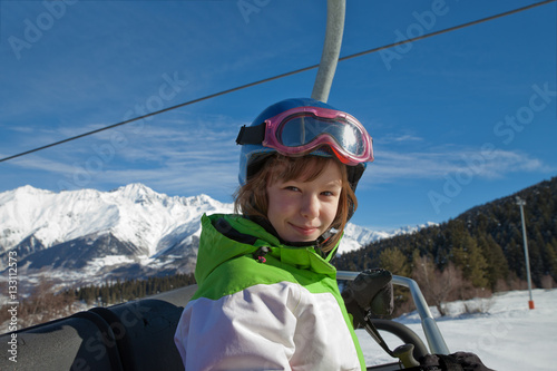 A smiling child invites everyone to climb a mountain and skiing. Winter vacations in the Caucasus, Georgia, Mestia. Children in the mountains.