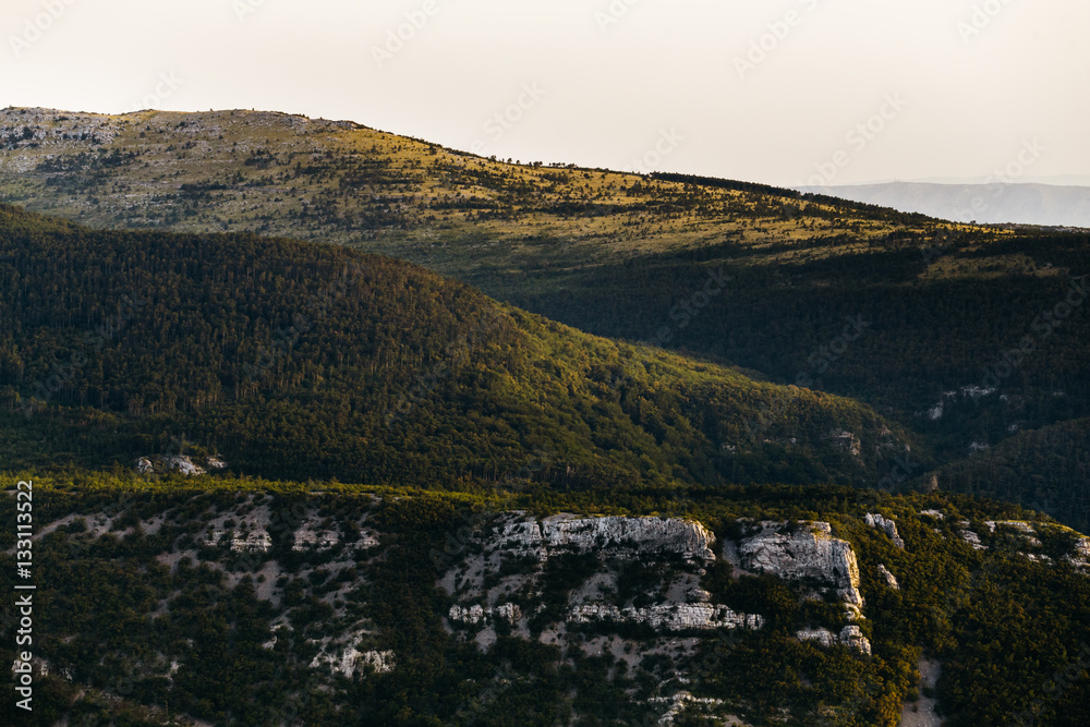 View of the hillside with rocks, forest in the rays of the setting sun in Croatia, Europe. View of the hillside with rocks, forest in the rays of the setting sun in Croatia, Europe.