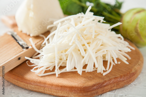 Fotografie the kohlrabi cabbage cut by straws on a board, selective focus