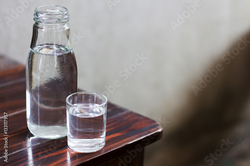 Drinking water in glass and bottle on a wooden floor.