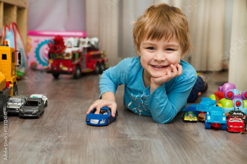 little boy plays with toy car at home
