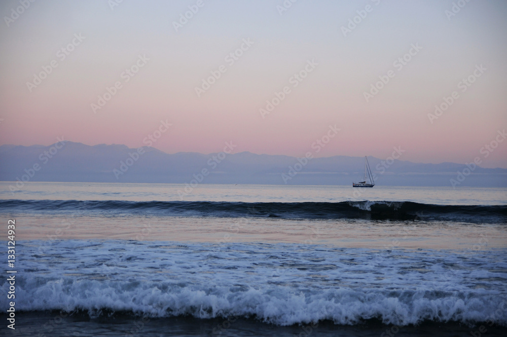 View of sea with boat and mountains in background View of sea with boat and mountains in background